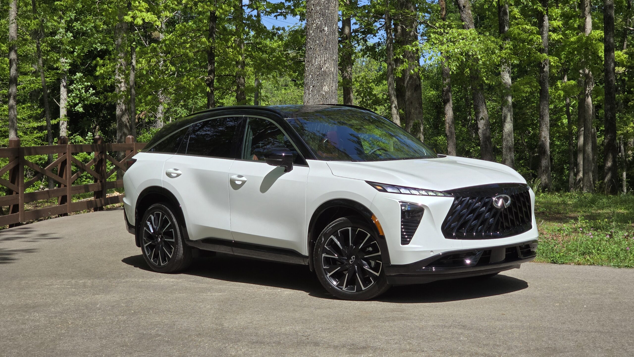 Front three-quarter view of the all-new white 2027 Infiniti QX65 luxury crossover parked outdoors.