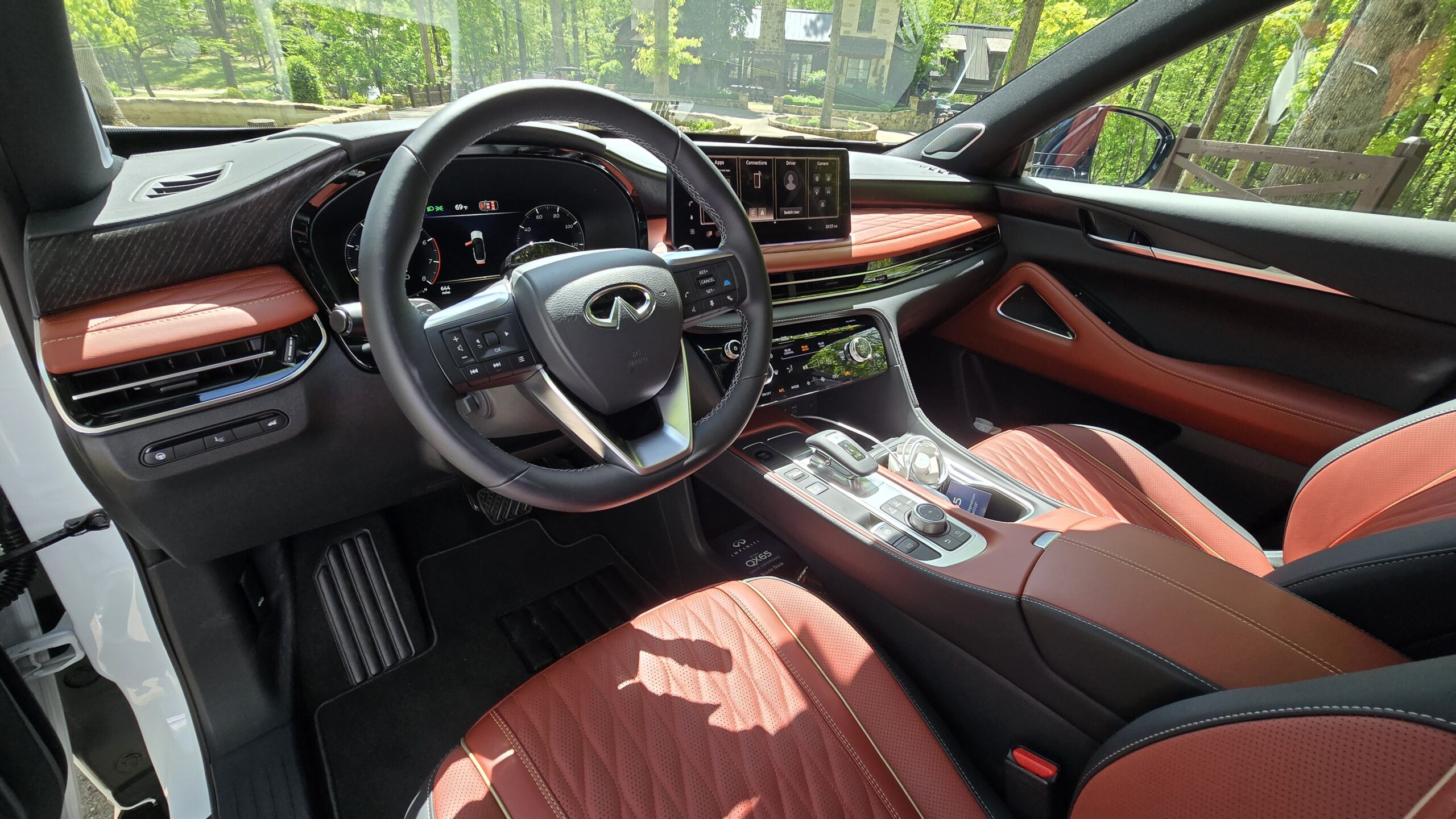 Interior cabin view of the 2027 Infiniti QX65 highlighting the premium red leather seats, steering wheel, and dual-screen displays.