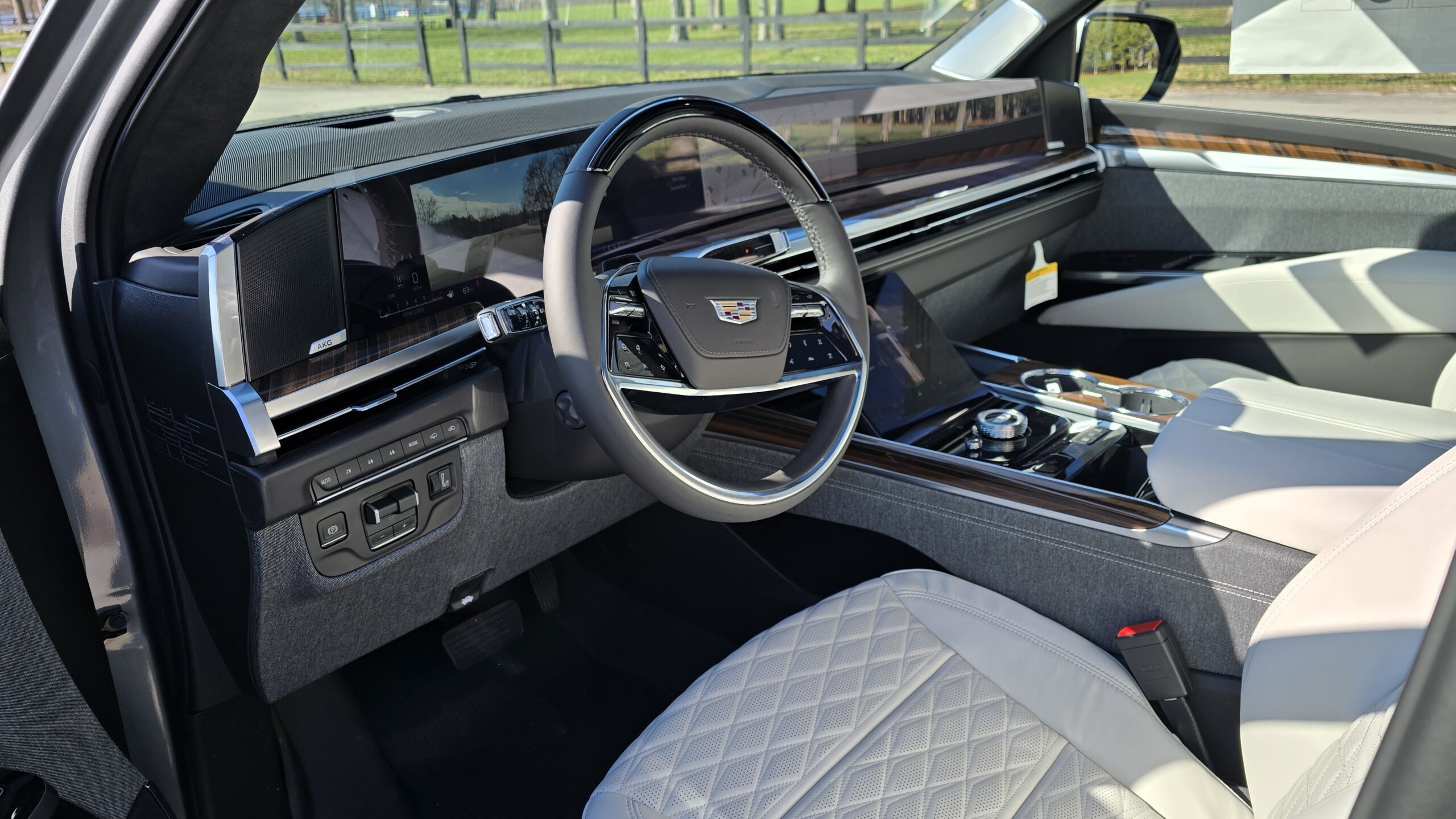 Interior cockpit view of 2026 Cadillac Escalade showing leather steering wheel and full-width 55-inch display