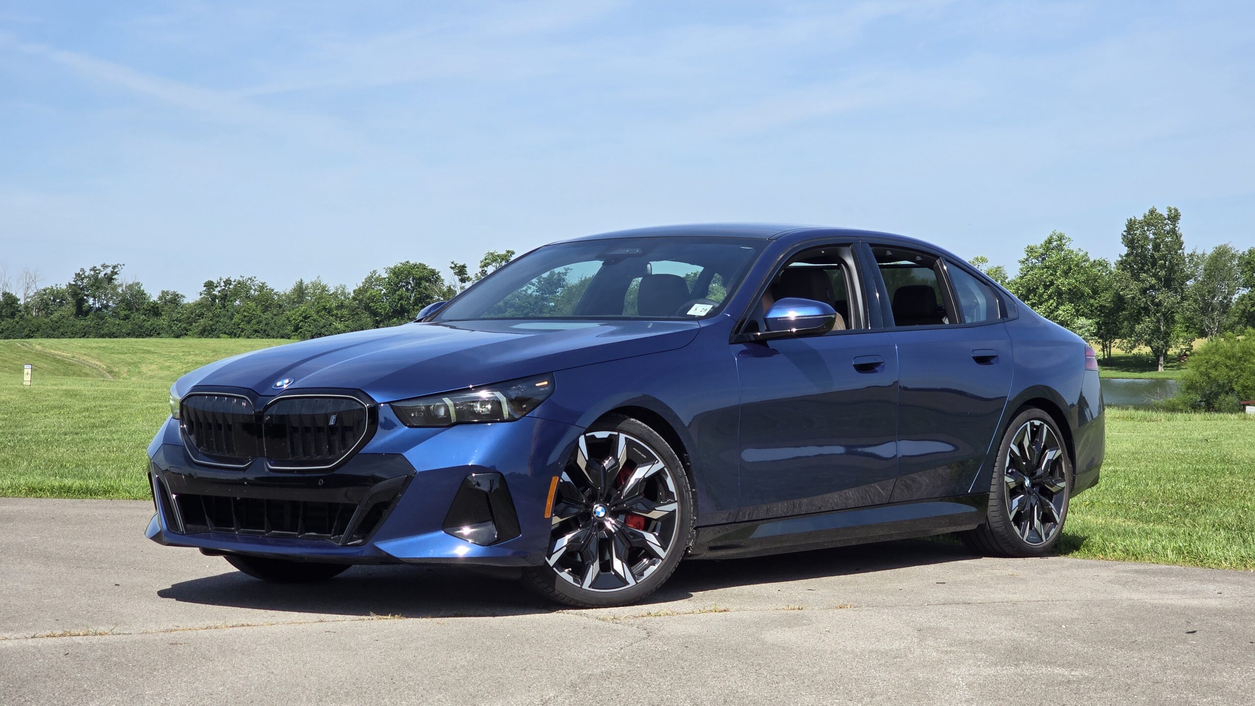 Front quarter exterior view of a dark blue 2026 BMW 5-Series luxury sedan